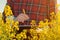 Oilseed rape farmer writing notes on clipboard notepad in blooming field