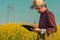 Oilseed rape farmer writing notes on clipboard notepad in blooming field