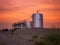 Oilwell at sunset with an orange and pink sky Landscape