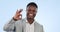 Ok, hand and face of black man with sign for yes in studio with emoji for thank you or agreement in business. Portrait