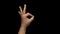 Ok hand gesture slow motion black background