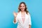 Ok sign, approval! Portrait of happy lovely woman doing okay gesture and smiling. blue background