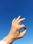 The okay gesture. is to unite the thumb and the index finger and the other straight ones with blue sky