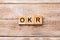 OKR word written on wood block. abbreviation of Objective Key Results text on wooden table for your desing, concept