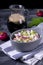 Okroshka soup with radish, sausage, cucumber, egg and potato in a ceramic bowl