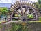 Old 18th century wooden water wheel in stone housing near on river Veules
