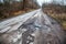 Old abandoned asphalt road with spoiled road markings