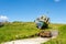 Old and abandoned boat on a hill with green grass next to an open car trailer on a farm