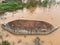 Old abandoned boat upside down in a muddy pond