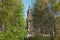 Old abandoned brick bell tower seen through the trees