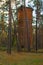 Old abandoned brick water tower in the autumn forest