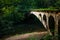 Old abandoned bridge over a forest river