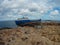 Old abandoned broken ship on the stoned coast sea side. cloudy sky storm time