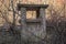 Old abandoned collapsed ventilation shaft among bushes and trees