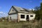 An old abandoned collapsing house. The broken roof and the falling brick from the walls.