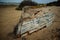 Old abandoned damaged fishing boat turned upside down at the beach