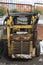 Old abandoned damaged rusty yellow mini loader tractor vertical close up back view