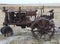 Old abandoned Farm Tractor sits beside a field