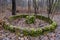 An old abandoned fountain made of bricks covered with green moss