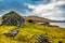 An old abandoned hamlet in the Faroe Islands. Mountains and lake on background