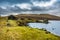 An old abandoned hamlet in the Faroe Islands. Mountains and lake on background