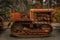 Old abandoned heavy equipment, tread tractor, amongst trees in a rural setting