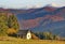 Old abandoned house and colorful dense forest in autumn time