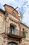 Old abandoned house frontage with balcony and falling gable