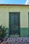 Old abandoned house or home with a weathered green wall and broken wooden door. Vintage and aged residential building