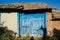 Old abandoned house`s facade, damaged painted wooden door/window, bulding exterior