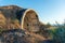 An old abandoned military tunnel, a semicircle of concrete inside a hill. side view