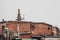 Old abandoned red brick  factory with chimney, outbuildings, and
