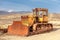 Old abandoned rusty caterpillar tractor on the street.