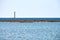 Old abandoned rusty sea pier for mooring boats and yachts on background of calm blue sea, horizon