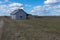 An old abandoned small wooden house in the fields sky clouds, barn or scary concept