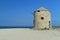Old abandoned stone-built windmill on the sandy beach of Lefkada