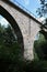 Old abandoned stone railway arch bridge over the river in the forest