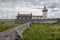 Old abandoned white light house. Cloudy sky