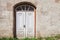 Old abandoned white wooden door in house at city street