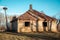 Old abandoned wooden house and stork nest on pile near it