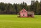 An old abondoned mansion in bad condition. Pink house on green field in countryside