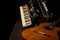 Old accordion and a beautiful guitar composing a scene on a rustic wooden surface with black background and low key lighting,