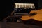 Old accordion and a beautiful guitar composing a scene on a rustic wooden surface with black background and low key lighting,