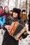 An old accordion players dressed in a Russian Ushanka