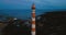 Old active lighthouse. Gloomy sky and cold blue atmosphere. Beach, north misty sea in vintage Scandinavian style