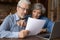 Old age married couple do paperwork engaged in reading document