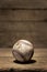 Old aged baseball in front of wooden background