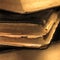 Old aged grungy vintage books sepia closeup, large detailed macro, gentle bokeh, black leather cover