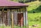 Old aged and weathered little farmhouse shed on a green field