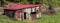 Old aged and weathered little farmhouse shed on a green field